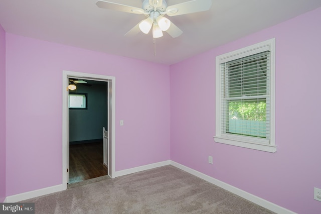 spare room featuring light colored carpet and ceiling fan