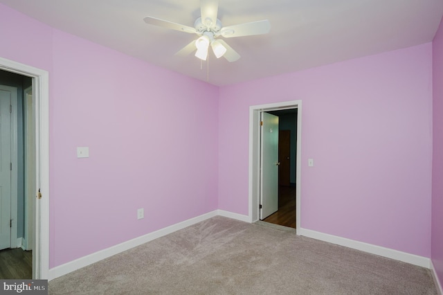 spare room with ceiling fan and light carpet