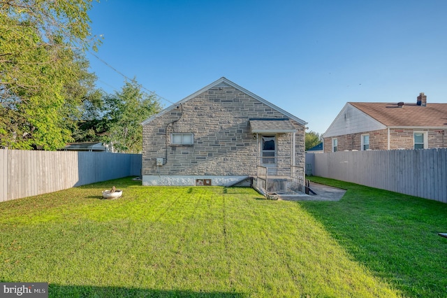 back of house featuring a lawn