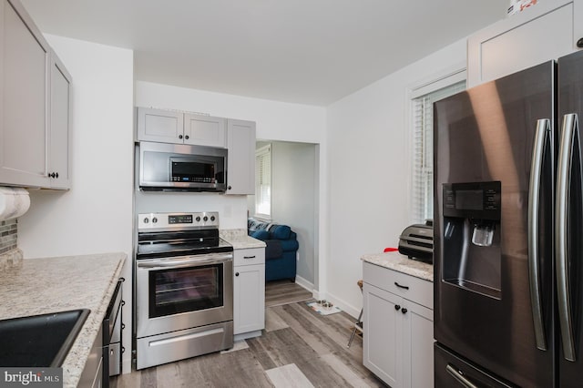 kitchen with sink, light wood-type flooring, and stainless steel appliances