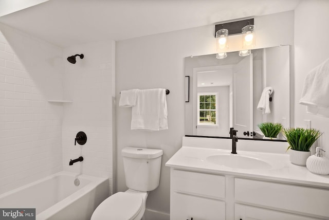 full bathroom featuring tiled shower / bath, vanity, and toilet