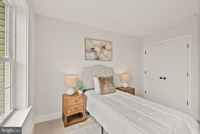 bedroom featuring light colored carpet and a closet