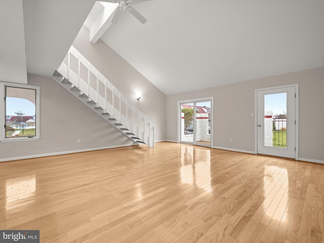 unfurnished living room with light hardwood / wood-style floors, high vaulted ceiling, and ceiling fan