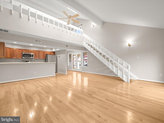 unfurnished living room featuring beamed ceiling, ceiling fan, high vaulted ceiling, and light hardwood / wood-style flooring