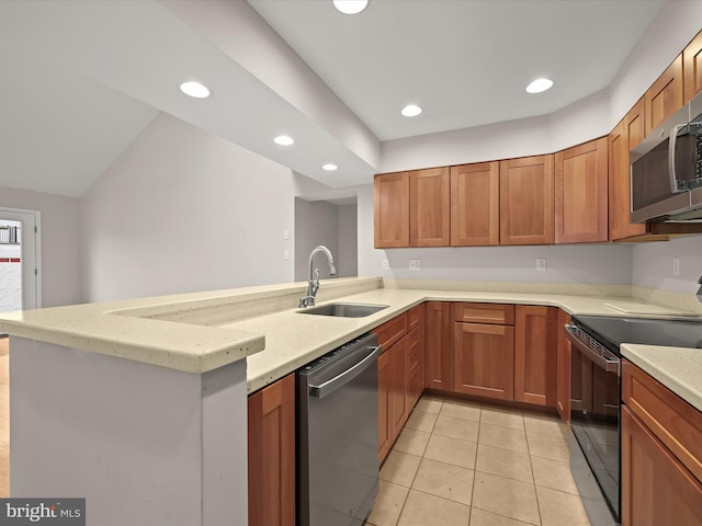 kitchen with kitchen peninsula, stainless steel appliances, light stone countertops, and sink