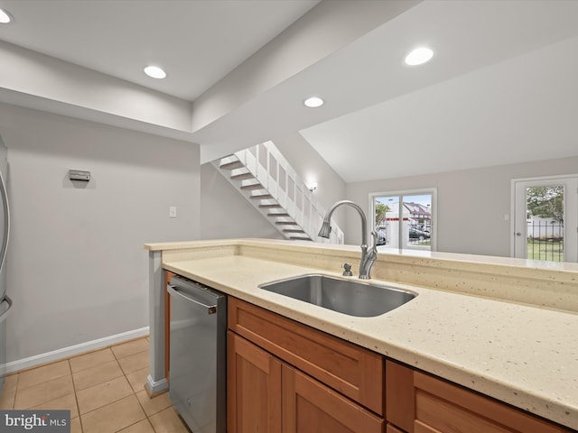 kitchen with dishwasher, light stone countertops, sink, and light tile patterned floors