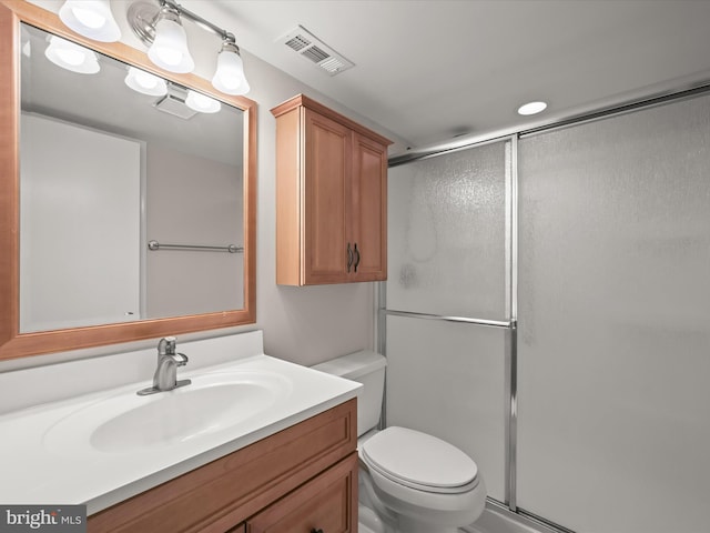 bathroom featuring vanity, toilet, and an enclosed shower