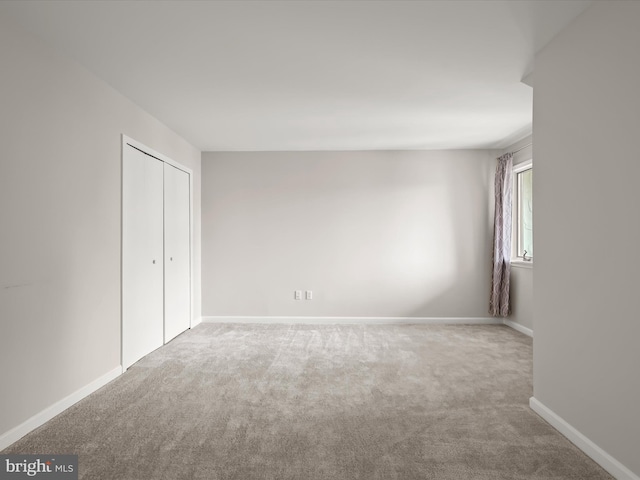 unfurnished bedroom with carpet flooring and a closet