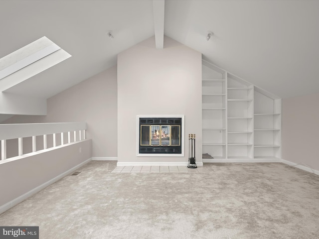 additional living space with built in shelves, lofted ceiling with skylight, and carpet floors