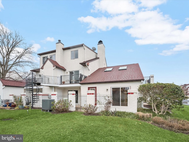 rear view of property with a lawn, a balcony, and cooling unit