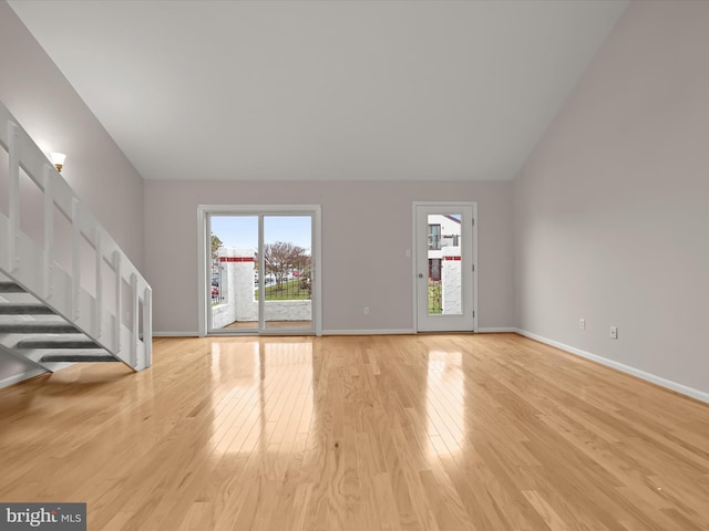 unfurnished living room featuring light hardwood / wood-style floors and lofted ceiling