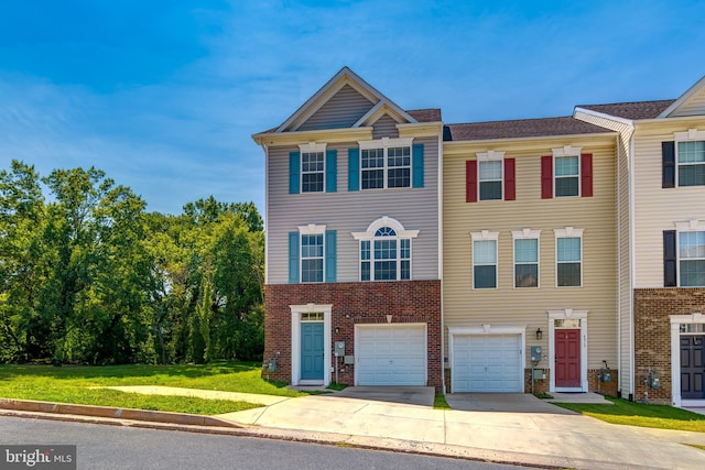 view of property featuring a garage and a front lawn