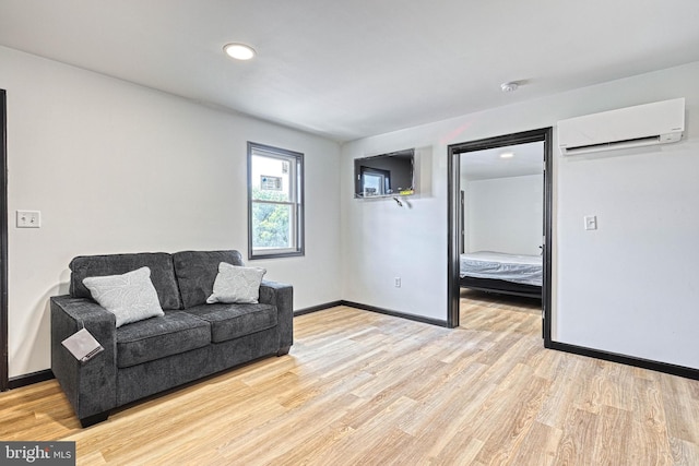 living room featuring an AC wall unit and light hardwood / wood-style floors