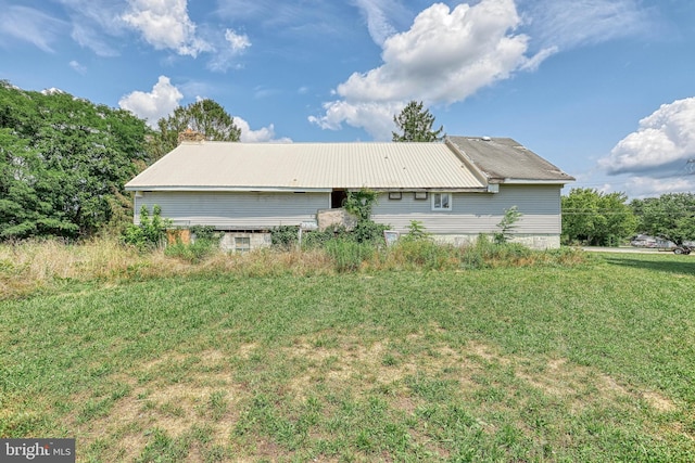 rear view of house featuring a lawn