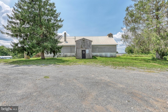 view of front of home with an outdoor structure and a front yard