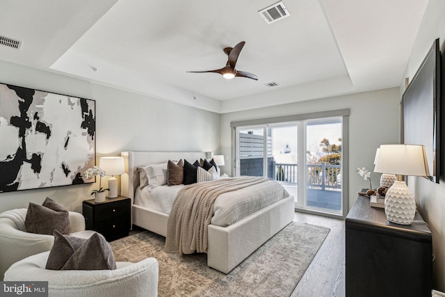 bedroom with access to exterior, light wood-style flooring, and visible vents