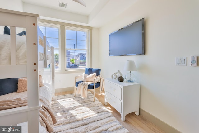 sitting room with wood finished floors, visible vents, and baseboards