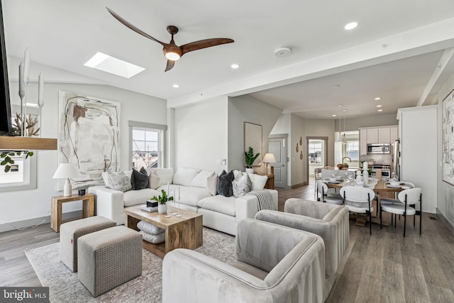 living room with a skylight, recessed lighting, and wood finished floors