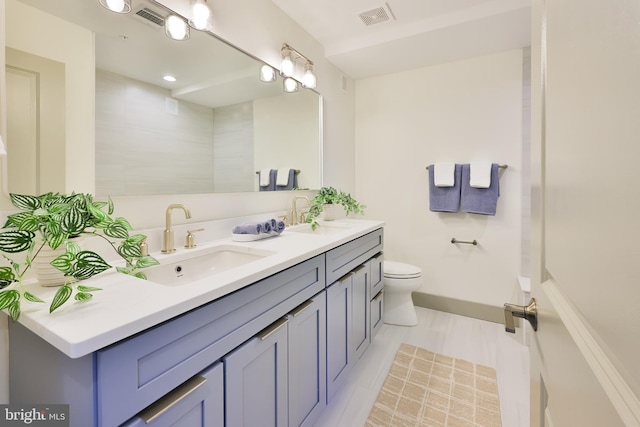 bathroom with double vanity, visible vents, toilet, and a sink