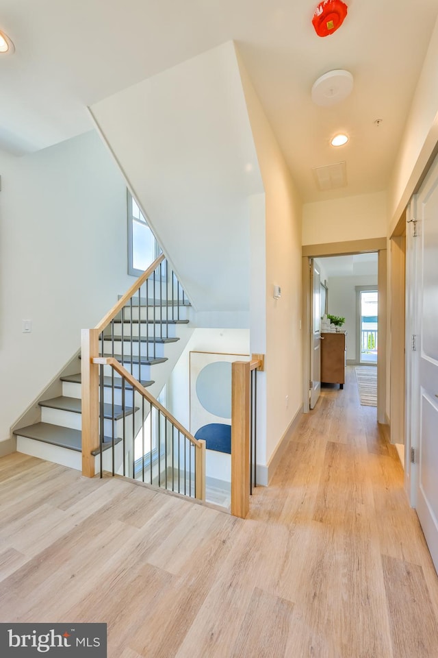 corridor with stairway, recessed lighting, baseboards, and wood finished floors