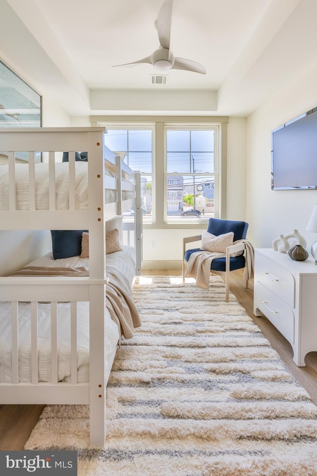 bedroom with visible vents, wood finished floors, and a ceiling fan