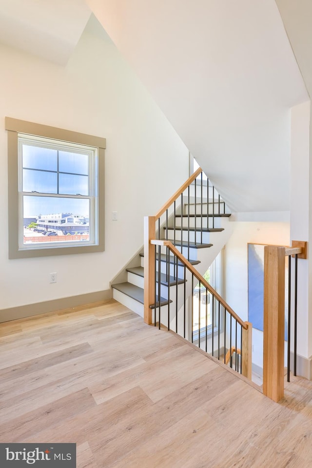 staircase with lofted ceiling and wood finished floors