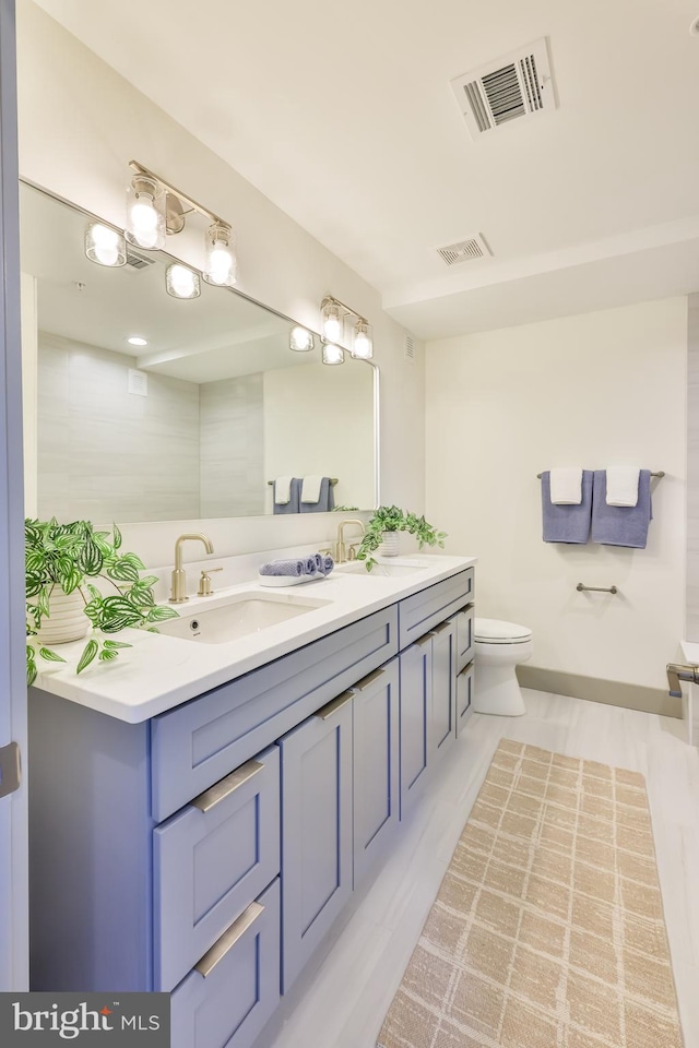 bathroom featuring a sink, visible vents, toilet, and double vanity