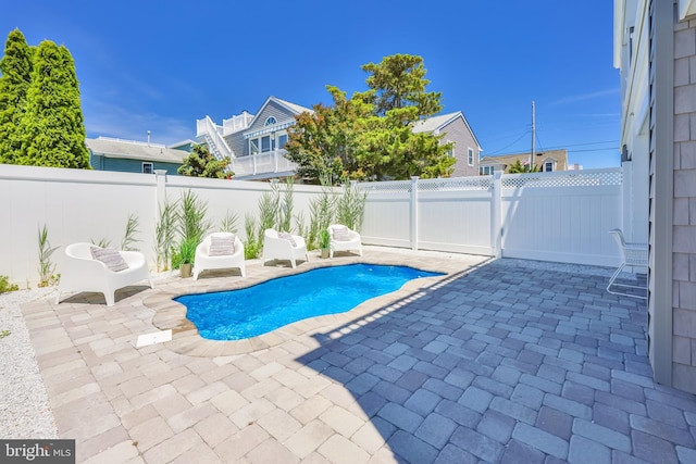 view of swimming pool featuring a fenced backyard, a fenced in pool, and a patio