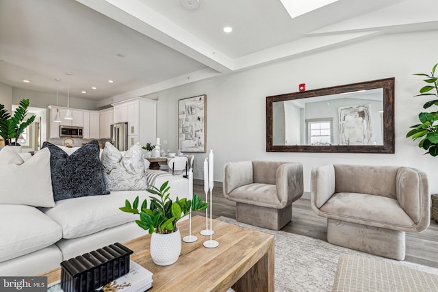 living area featuring recessed lighting, baseboards, wood finished floors, and a skylight