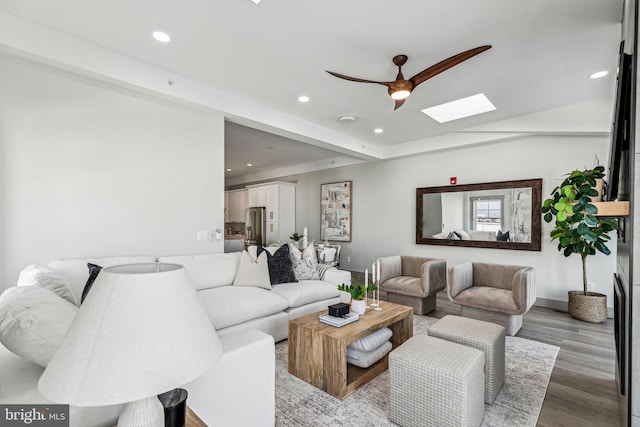 living area featuring a skylight, recessed lighting, wood finished floors, and ceiling fan