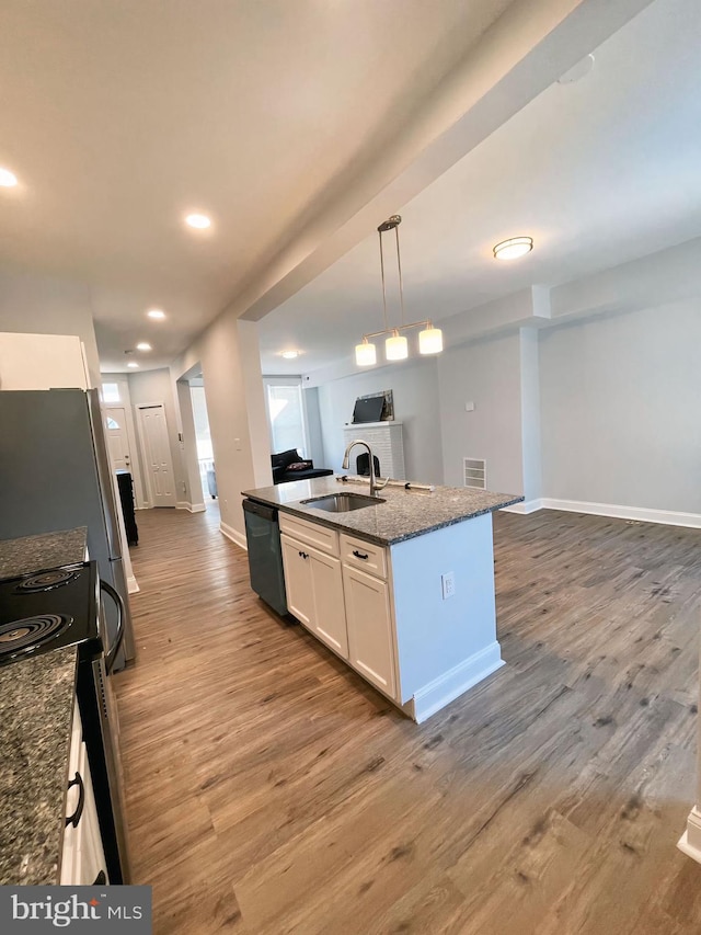 kitchen featuring white cabinets, sink, electric range oven, a kitchen island with sink, and dishwasher