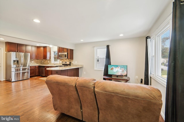 living room with sink, light hardwood / wood-style flooring, and a healthy amount of sunlight