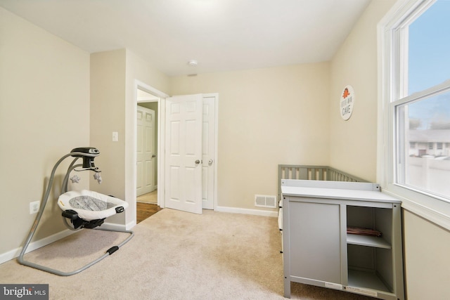 carpeted bedroom featuring a nursery area