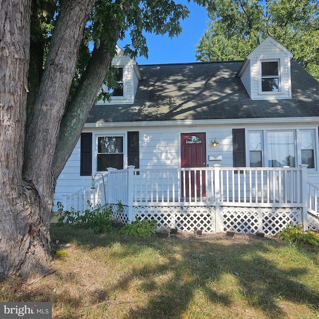 new england style home with a front lawn and a deck