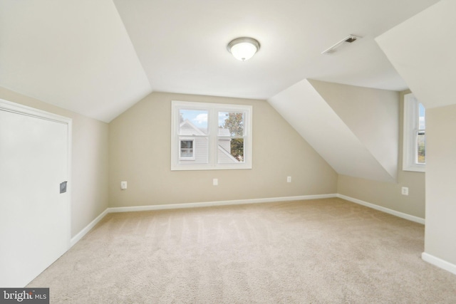 bonus room featuring light colored carpet and vaulted ceiling