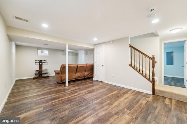 basement featuring electric panel and dark hardwood / wood-style flooring