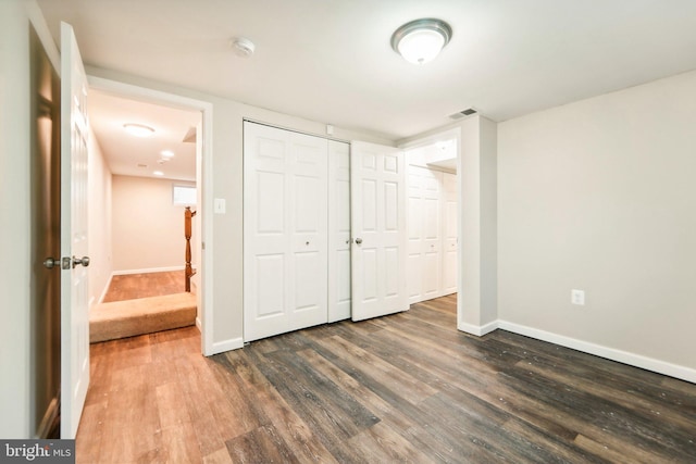 unfurnished bedroom with a closet and dark hardwood / wood-style flooring