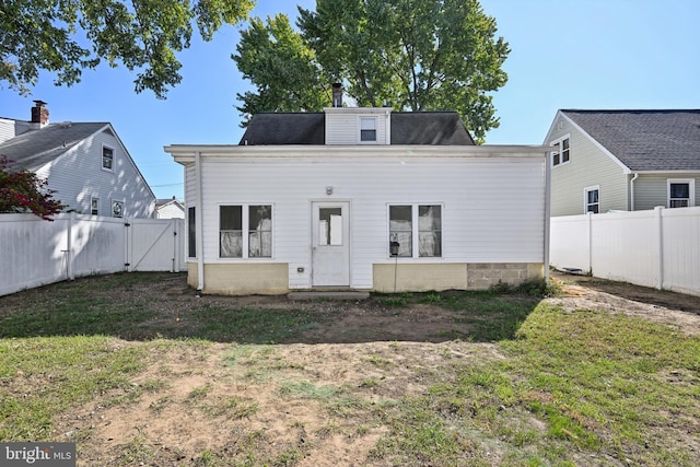 rear view of property featuring a lawn