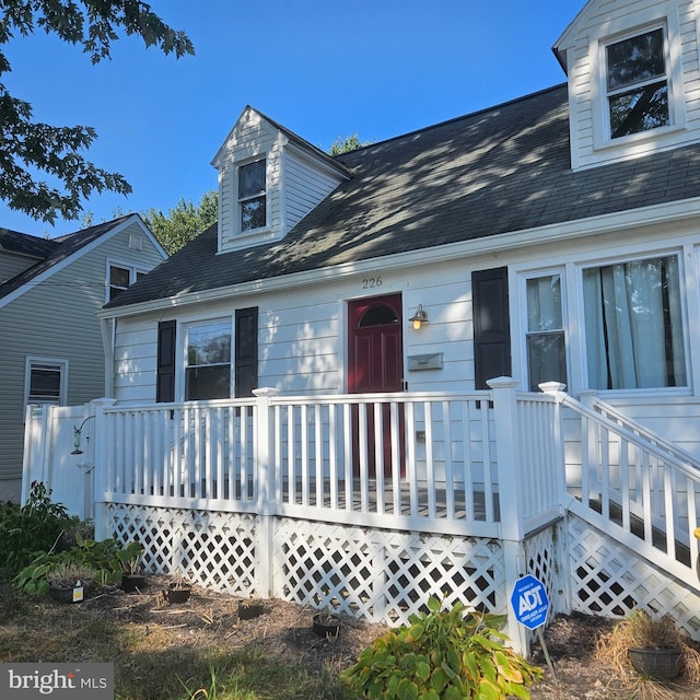 cape cod home with a wooden deck