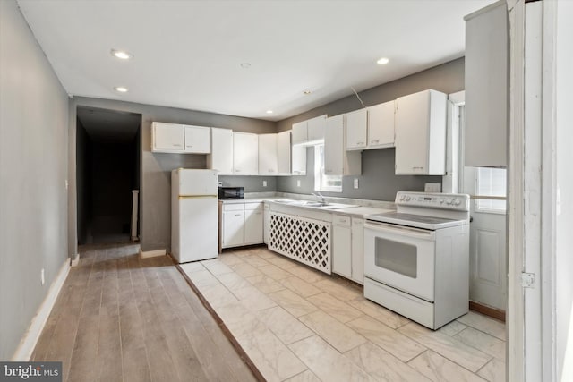 kitchen featuring white appliances, sink, light hardwood / wood-style flooring, and white cabinets