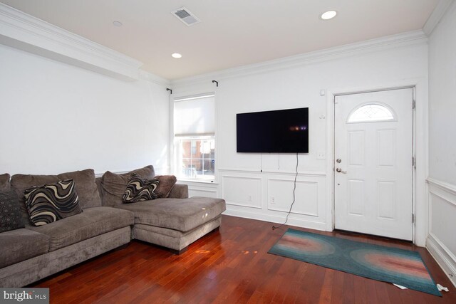 living room featuring dark hardwood / wood-style floors, a chandelier, and crown molding