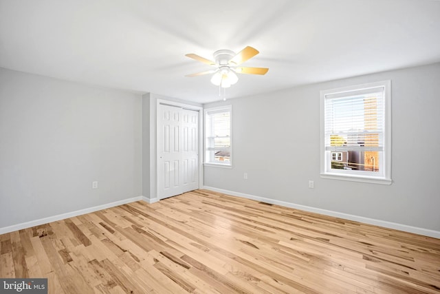 unfurnished bedroom featuring ceiling fan, light wood-type flooring, and a closet