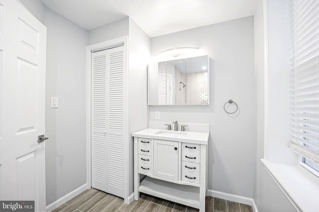 bathroom with a shower, hardwood / wood-style flooring, and vanity