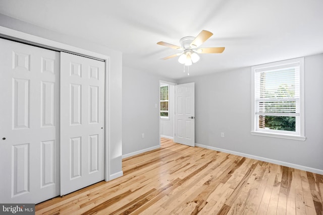 unfurnished bedroom with ceiling fan, a closet, and light hardwood / wood-style flooring