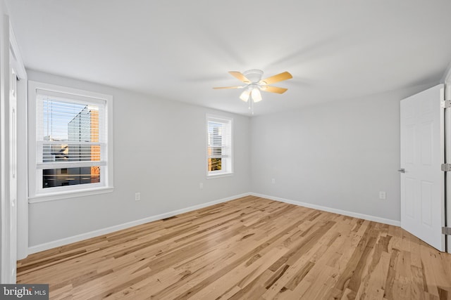 unfurnished room featuring ceiling fan, light hardwood / wood-style flooring, and a healthy amount of sunlight