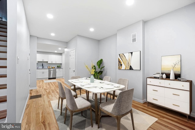 dining room featuring sink and light wood-type flooring