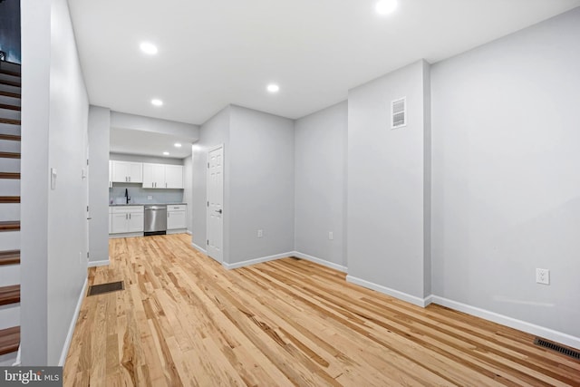 unfurnished living room with light hardwood / wood-style flooring and sink