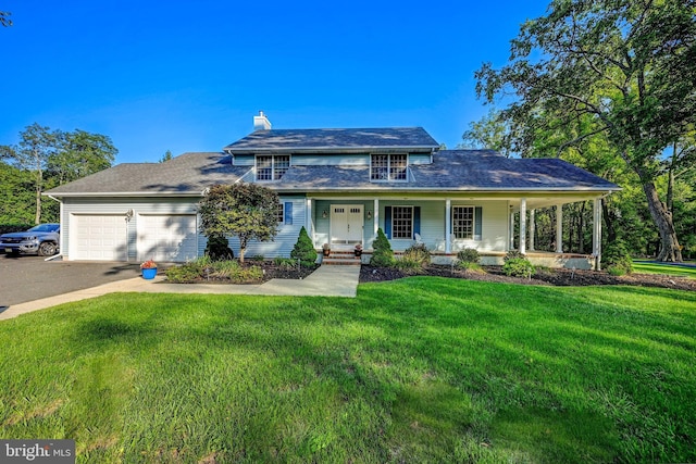 view of front of house featuring a front yard, a garage, and a porch