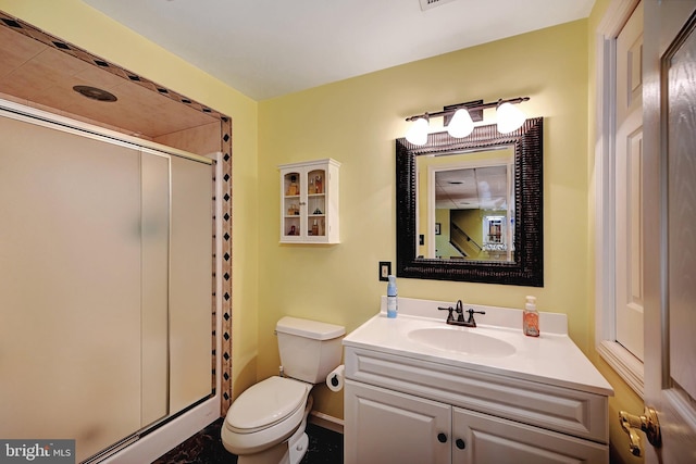 bathroom with walk in shower, vanity, and toilet