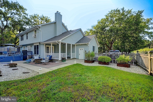 rear view of house featuring a wooden deck and a lawn